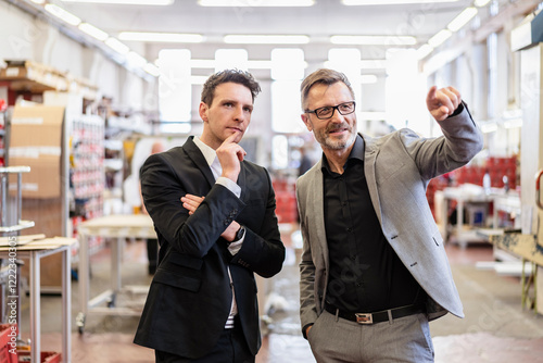 Two businessmen talking in a factory