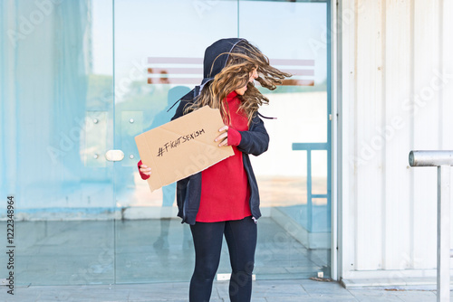 Screaming teenage girl showing the hashtag fight sexism on cardboard photo