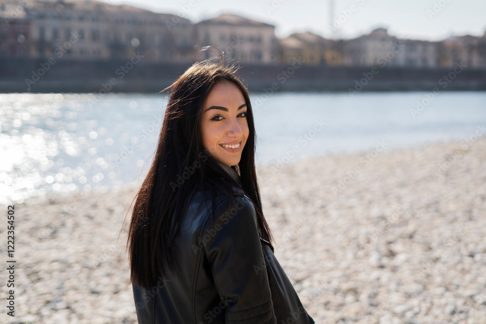 Italy, Verona, portrait of smiling young woman at the riverside Italy, Verona, portrait of smiling young woman at the riverside