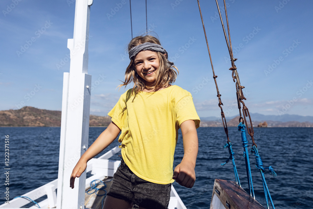 Indonesia, Komodo National Park, portrait of happy girl on a sailing boat Indonesia, Komodo National Park, portrait of happy girl on a sailing boat