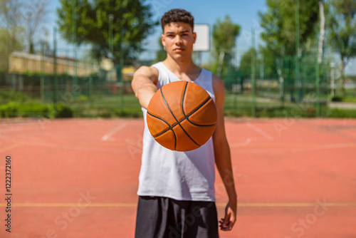 Young man playing basketball, giving the basketball photo