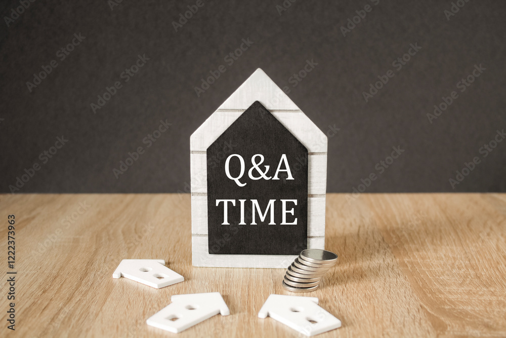 Concept words 'Q and A time' on black blackboard. Beautiful wooden table, black background. A stack of coins. Business and Q and A time concept.