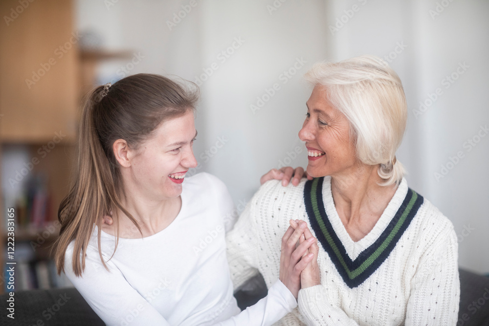 Laughing mother and adult daughter looking at each other Laughing mother and adult daughter looking at each other