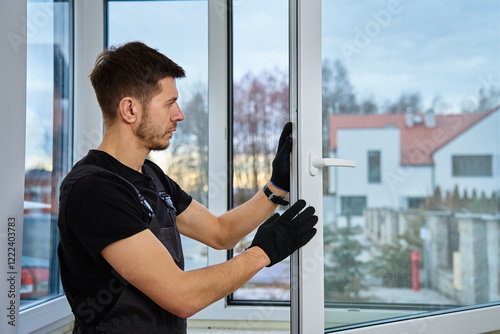 Professional repairman adjusting white pvc windows in modern building. Construction worker installing plastic window in new home. Concept of repair and maintenance