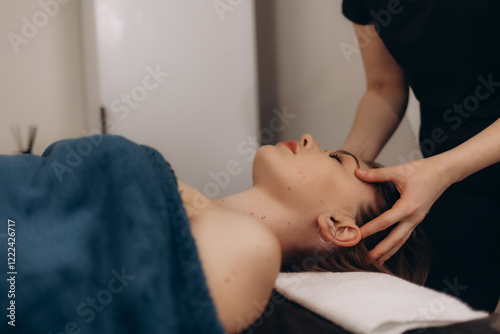 Beautiful young woman getting a face treatment at beauty salon. photo