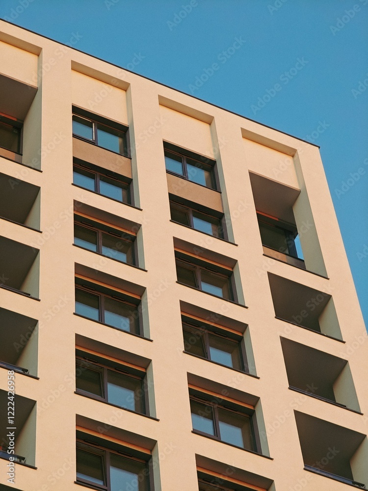 Modern apartment building facade against a clear blue sky. Lodz, Poland