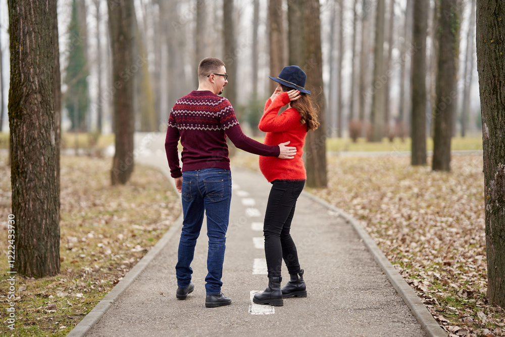 Fototapeta premium Expecting couple walking hand in hand outdoors