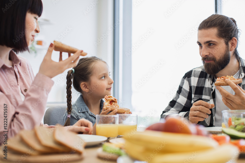 Caucasian family having pizza for breakfast at home. Parents and daughter enjoying meal together, sharing smiles and conversations. Caucasian family having pizza for breakfast at home. Parents and daughter enjoying meal together, sharing smiles and conversations.