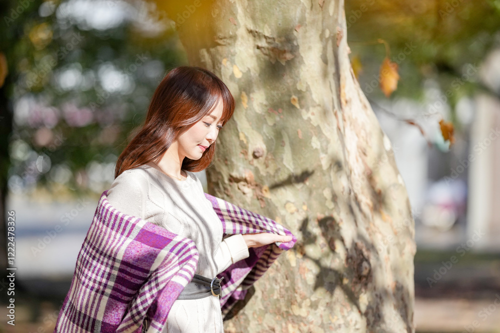 A woman with long hair in her thirties stands in a beautiful autumn leaves in a beautiful autumn leaves A woman with long hair in her thirties stands in a beautiful autumn leaves in a beautiful autumn leaves