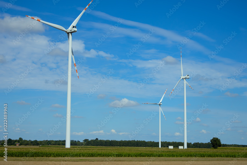 Three wind turbines generate renewable energy under a clear blue sky in a rural area Three wind turbines generate renewable energy under a clear blue sky in a rural area