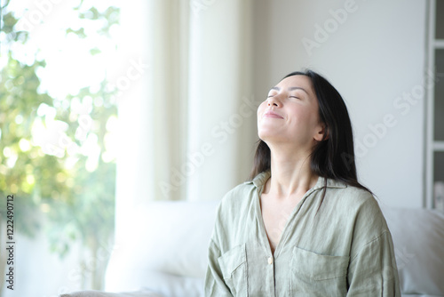 Asian woman breathing fresh air at home photo