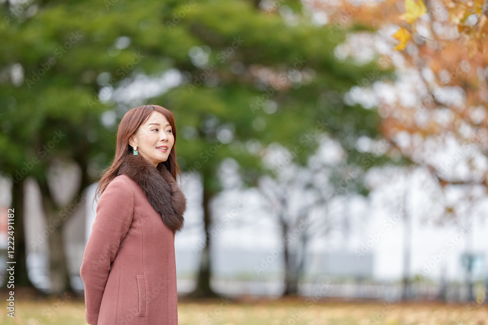 A woman with long hair in her thirties stands in a beautiful autumn leaves in a beautiful autumn leaves A woman with long hair in her thirties stands in a beautiful autumn leaves in a beautiful autumn leaves