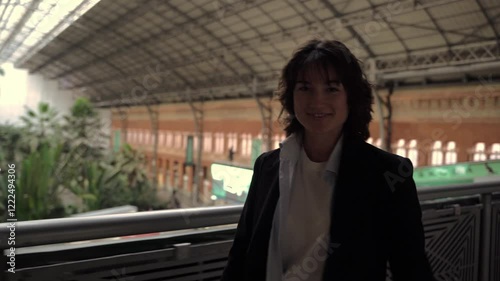 Businesswoman exuding confidence while smiling at atocha station's balcony