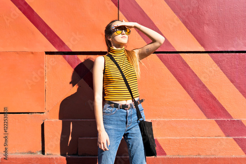 Teenage girl at a wall enyoying the sunshine