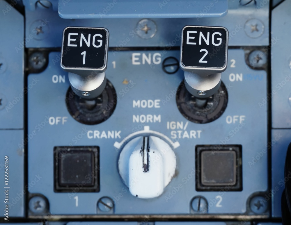 Close-up of an aircraft engine control panel with switches and dials in a cockpit setting. Close-up of an aircraft engine control panel with switches and dials in a cockpit setting.