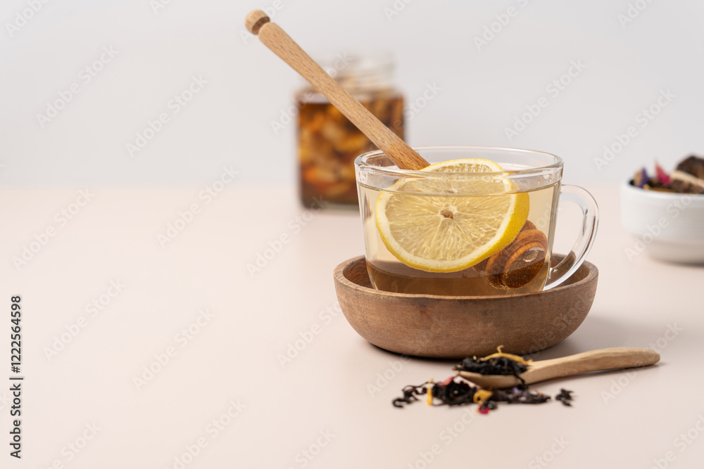 Tea, lemon, honey in glass mug on light background with copy space. Health drink close-up view Tea, lemon, honey in glass mug on light background with copy space. Health drink close-up view
