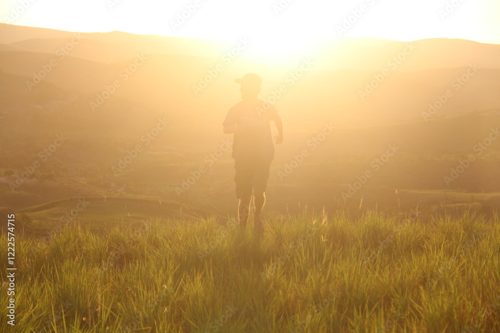 homem caminhando com montanhas ao fundo na golden hour homem caminhando com montanhas ao fundo na golden hour