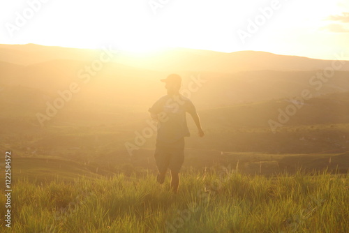 homem com montanhas ao fundo na golder hour photo