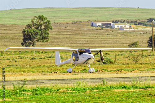 White two-seater single engine light-sport high-wing aircraft on grass airstrip in the Western Cape, South Africa photo