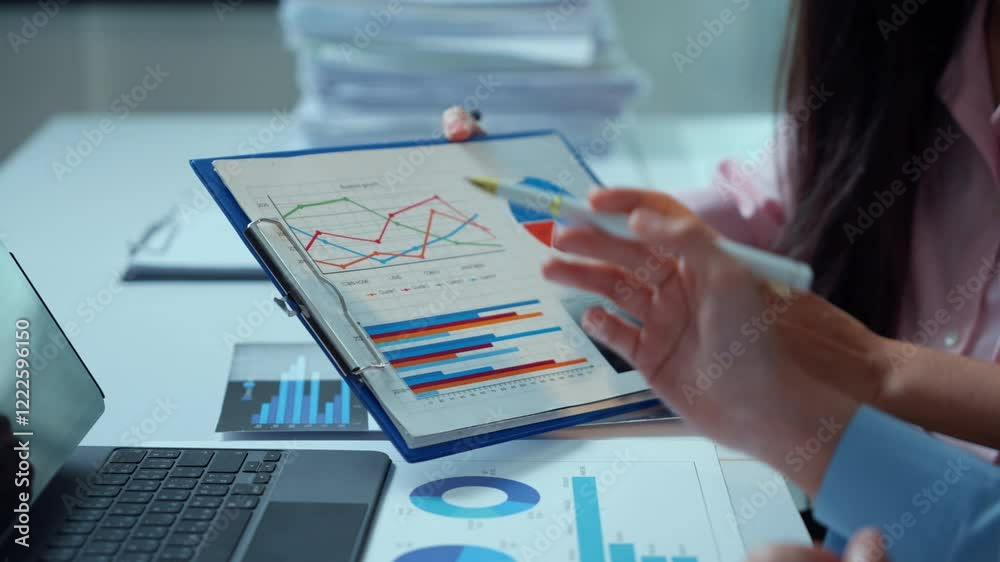 Professional team members reviewing financial metrics, sharing data driven insights, brainstorming strategy in modern corporate workspace with graphs and charts