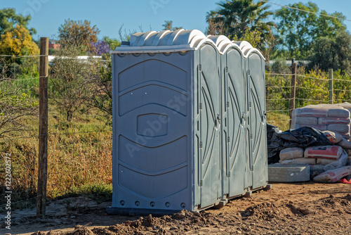A row of three portable toilets made from plastic on a construction site in the Western Cape, South Africa