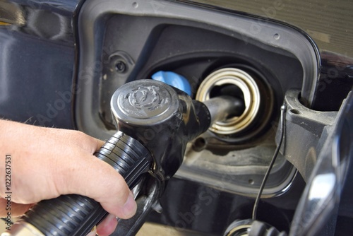A man operates a pump for filling with gasoline and diesel.