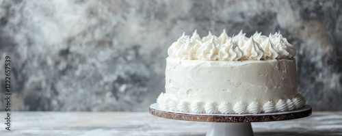 Elegant white cake with whipped cream frosting on cake stand