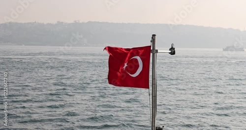 Captivating slow motion view of the Turkish flag on a ship cruising the Istanbul Bosphorus. Cinematic and high quality city silhouette.