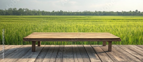 Wooden table centered in the foreground against vibrant green rice field background with soft natural lighting enhancing product visibility