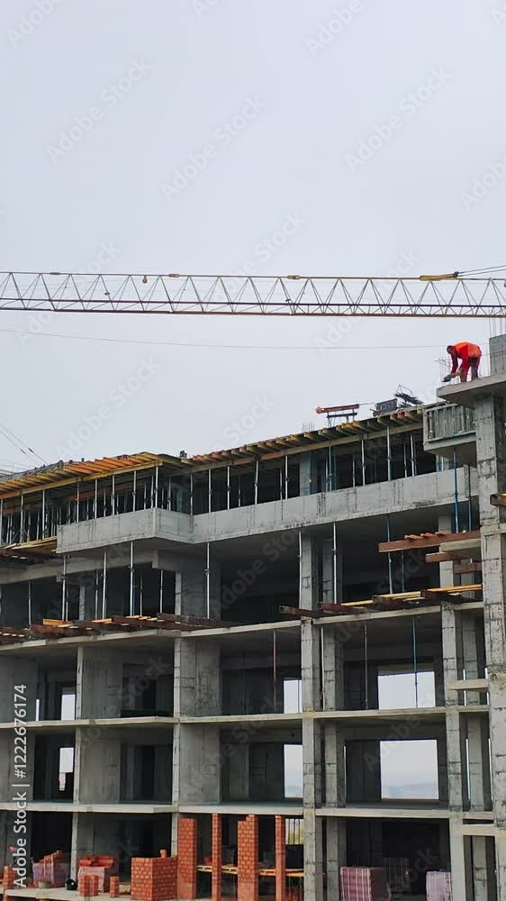 Drone view on a new construction site. Working process of construction the modern building on the background of two big cranes in the city. Vertical video Drone view on a new construction site. Working process of construction the modern building on the background of two big cranes in the city. Vertical video