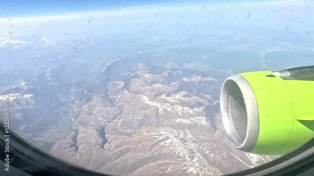View from the window of the airplane. Flight over the mountains of Georgia. Mountain peaks from an airplane window. View from the window of the airplane. Flight over the mountains of Georgia. Mountain peaks from an airplane window.