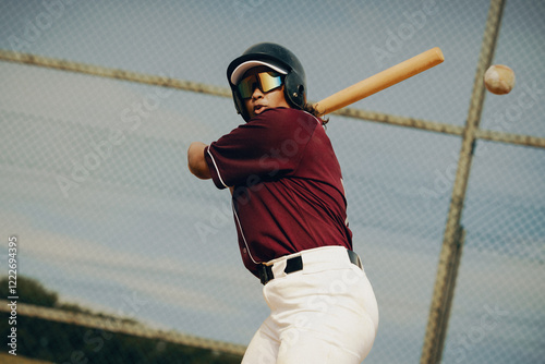 Baseball player mid-swing, preparing to hit the ball during an outdoor game