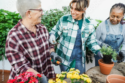 Multiracial women preparing flowers plants at home garden shop outdoor - Spring time and gardening concept - Main focus on left woman face