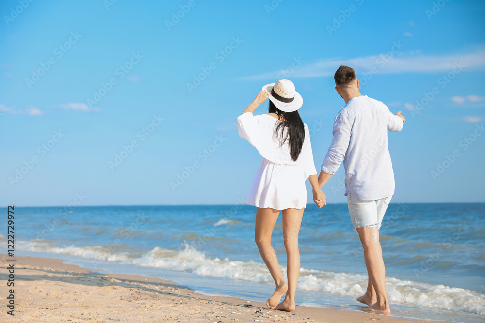 Lovely young couple walking at beach on sunny day Lovely young couple walking at beach on sunny day
