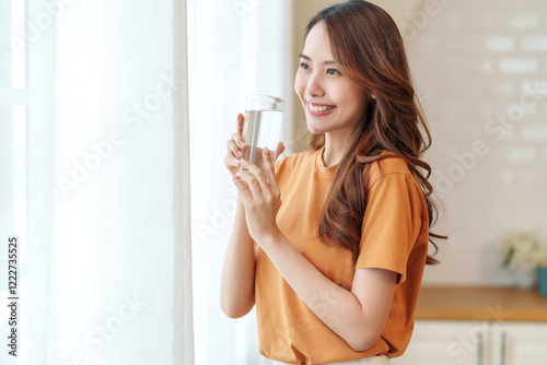 portrait smiling young woman with a glass of fresh water relaxing in the room,people with healthy lifestyle,health,beauty,health care