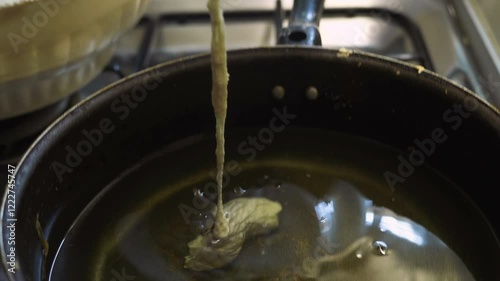 Making zeppole : putting dough in hot olive oil. South of Italy photo