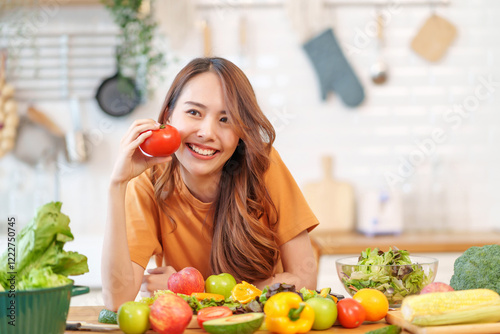 portrait freshy young asian woman having fun in the kitchen,hand holding ripe tomato for cook,healthy food,nutrition,vitamin,beauty,health