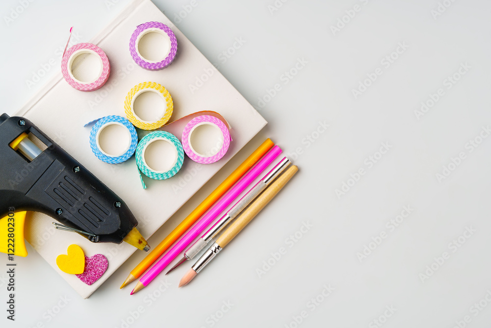 Crafting supplies arranged for creative projects with glue gun, decorative tape, and colorful pencils Crafting supplies arranged for creative projects with glue gun, decorative tape, and colorful pencils