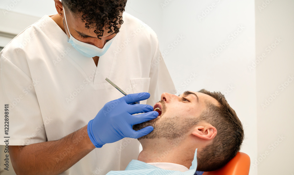 Fototapeta premium Dentist carefully performing a routine oral examination and treatment on a male patient in a modern and clean dental clinic