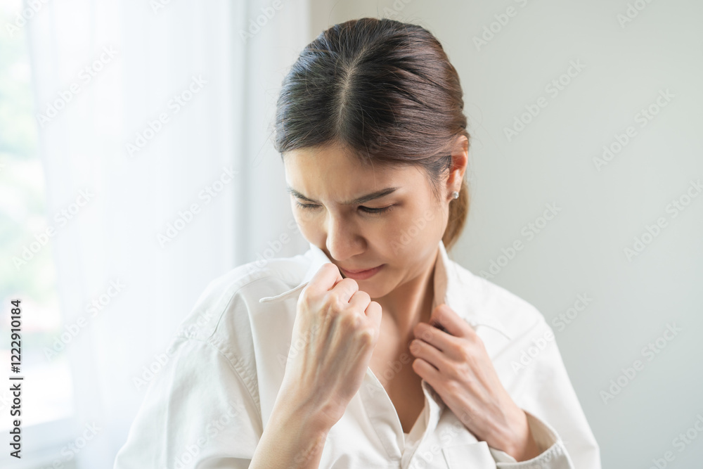 Bad smell nose concept asian young housewife woman having smelling clothes her shirt collar, sniff smelly dirty stinky musty, look disgusting from clothes after washed, laundry out of machine at home. Bad smell nose concept asian young housewife woman having smelling clothes her shirt collar, sniff smelly dirty stinky musty, look disgusting from clothes after washed, laundry out of machine at home.