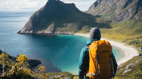 Hiker contemplating stunning coastal scenery with backpack overlooking tranquil beach and mountains under blue sky photo