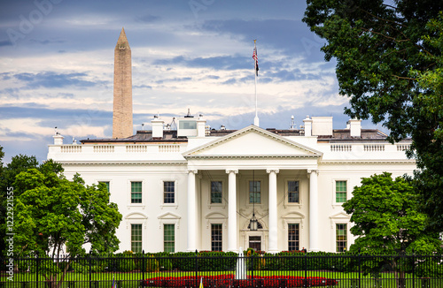 Obraz na płótnie The White House with the Washington Monument in the background, captured on a cloudy day in Washington. A view of iconic American landmarks surrounded by greenery and historical charm. US Presidenct w salonie
