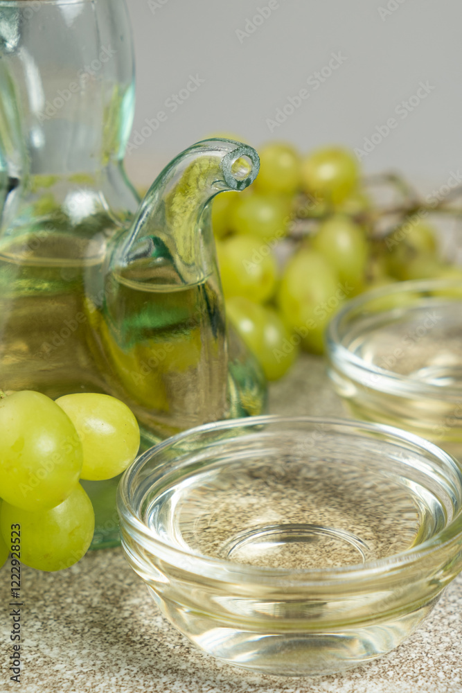 White wine vinegar in a vinegar bowl among grapes White wine vinegar in a vinegar bowl among grapes