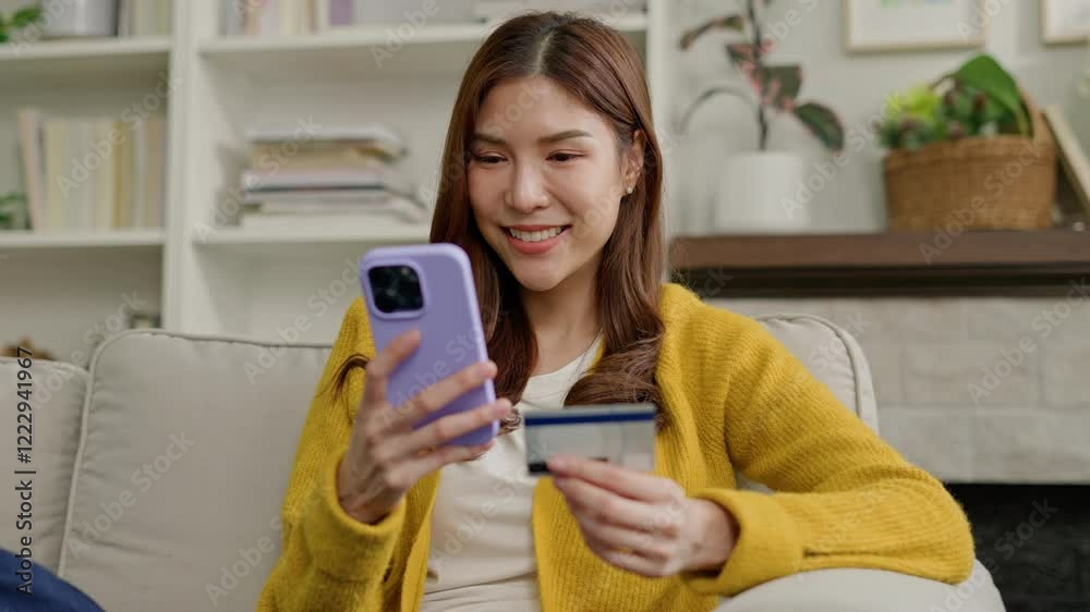 credit card and smartphone in female hands.Asian young woman in defocus looks at the phone screen,payment shopping online.Credit card and phone in the focus credit card and smartphone in female hands.Asian young woman in defocus looks at the phone screen,payment shopping online.Credit card and phone in the focus