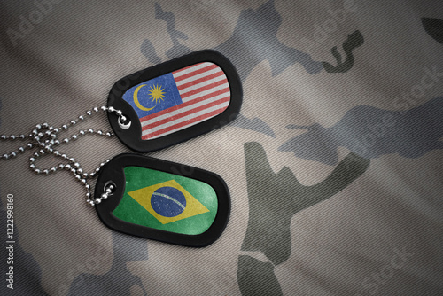 vintage army blank, dog tag with flag of malaysia and brazil on khaki texture background. military concept. photo