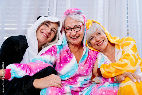 Beautiful senior women having cool pajama party at home - Group of cheerful elderly female friends having fun at home with funny costumes, concepts about old people, lifestyle and quality of life