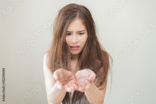 Serious, worried asian young woman, girl holding, show damaged loss hair, problem after brushing, hair fall out on hand. Health care of beauty treatment. Portrait isolated on background, copy space.