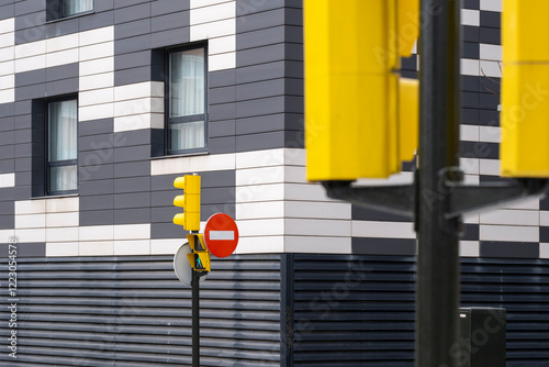 The intersection features vibrant traffic signals against a contemporary building facade, merging urban life with modern architecture and design aesthetics. photo