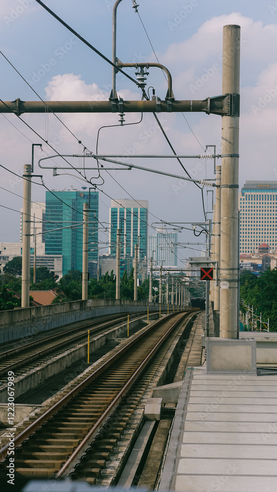 Fototapeta premium MRT Urban Railway Infrastructure with Modern City Backdrop