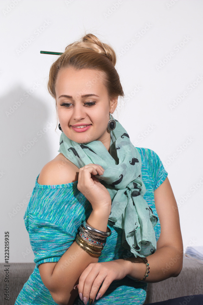 Woman with a bun and bracelets sitting on a sofa